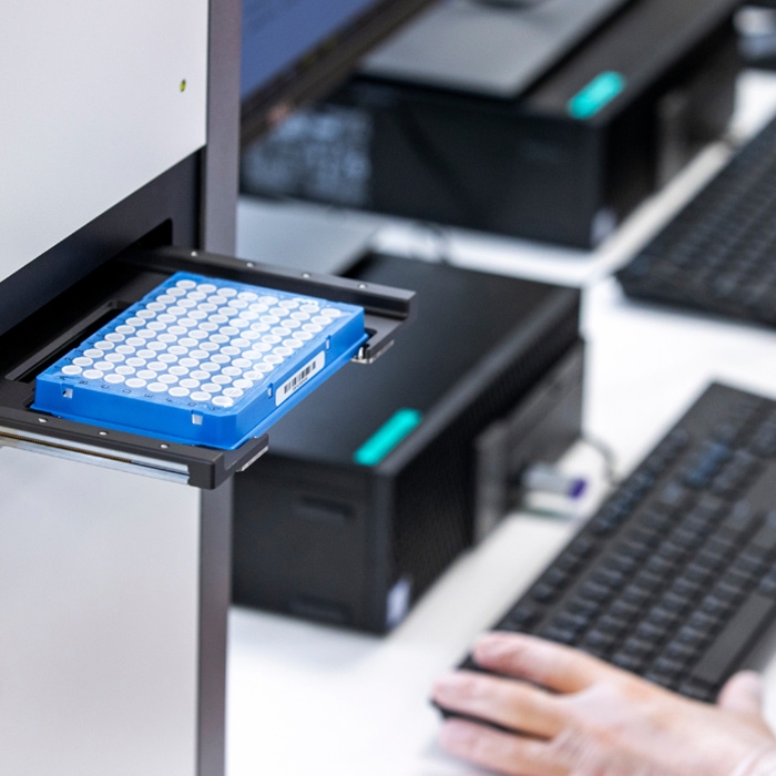 Eonis™ Q newborn screening instrument with the drawer open and a microplate positioned on the tray.