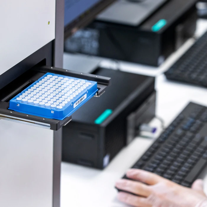 Eonis™ Q newborn screening instrument with the drawer open and a microplate positioned on the tray.